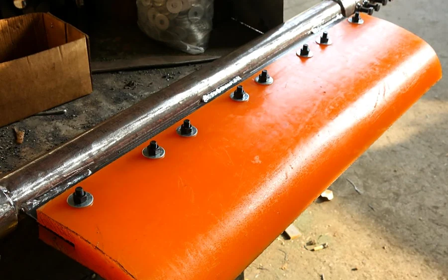 Polyurethane scraper blade mounted on a steel bar